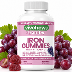 A bottle of vivchews Ironitis Grape gummies with Vitamin C, flanked by fresh grape leaves, whole grapes, and sliced strawberries on a white background.