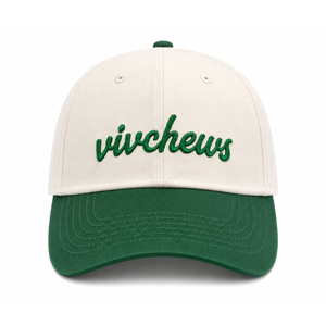 A baseball cap with an off-white crown and a dark green curved brim, featuring the word 'vivchews' embroidered in green script across the front.